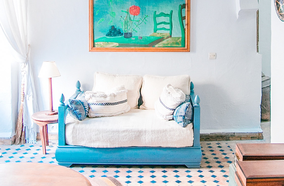 blue and white sofa with a painting above it