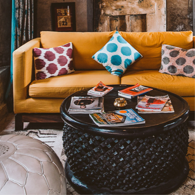 round coffee table placed in front of a yellow sofa